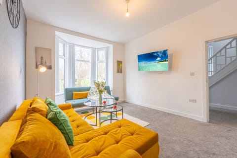 Living room with sofa seating and a wall-mounted TV.