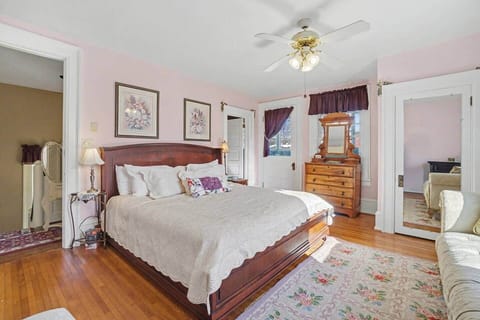 Large, comfortable king-size bed on solid wood frame with vintage furniture.