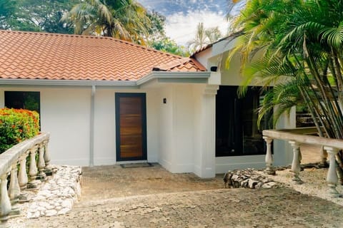 Frente de la casa con acceso privado y espacio de estacionamiento.