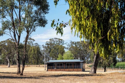 The cottage exterior sits within a serene countryside setting, blending contemporary design with its rural surroundings.