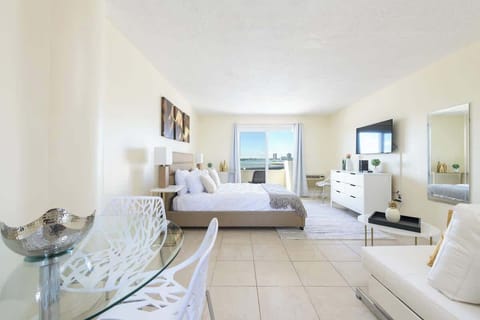 Wake up to water views from this serene bedroom with balcony seating, perfect for your coastal escape.