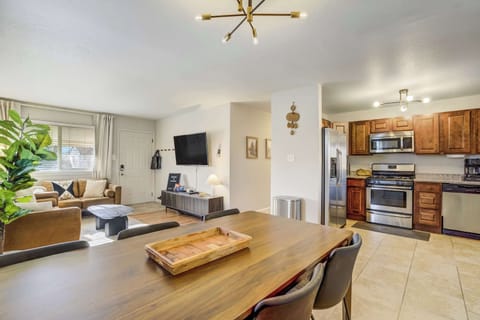 The dining area serves as a natural bridge between the kitchen and living room. Potted greenery and modern fixtures enhance the bright, open layout, providing an inviting space for family meals and conversation.