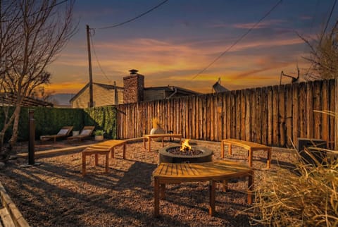 Welcome to Carson Camp! Unwind under the stars in this private, fenced yard where six curved wooden benches surround a central fire pit, creating an inviting and dedicated space for evening gatherings, storytelling, and shared conversation.