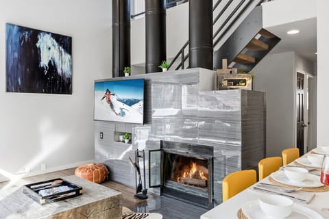 Living room: Wood-burning fireplace, 55” Smart TV, mountain views, balcony access