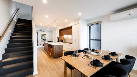 Dining space for gathering beside sleek black staircase feature.