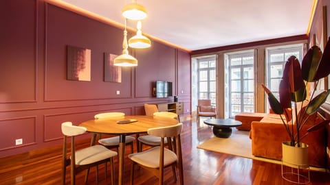 Spacious open-plan living and dining area with rich burgundy walls, designer lighting, and large traditional Porto windows filling the space with natural light.
#PortoApartment #PortoLiving #DesignApartment #StayInPorto #PortoTravel