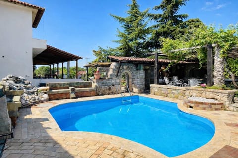 Outdoor pool surrounded by stone terraces and greenery, ideal for cooling off and enjoying sunny days with family or friends.