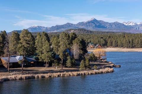 Stunning lakeside setting with majestic mountain backdrop and peaceful forested surroundings creates an idyllic retreat atmosphere.
