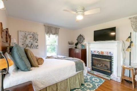 Queen size bed in front of a gas fireplace. Plenty of natural light and a kitchenette.