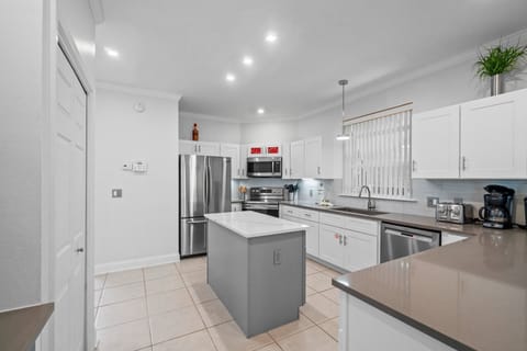 Fully equipped kitchen with stainless appliances, island seating, and ample counter space.