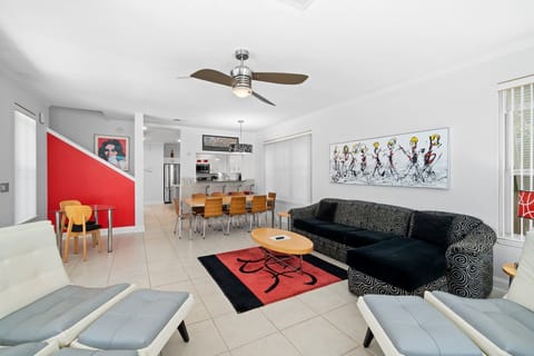 Open-concept living space with comfortable seating, dining table, and coastal artwork.