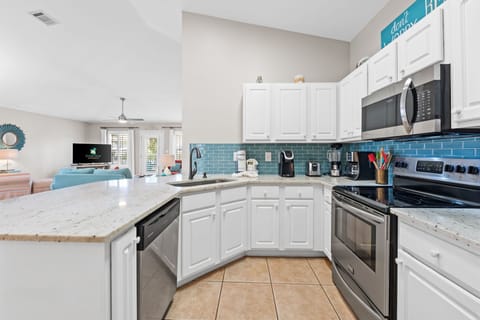 The kitchen is equipped with plenty of dishes, pots, pans and flatware.