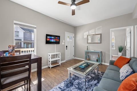 Stylish living area with dining table, Smart TV, ceiling fan, and plenty of natural light