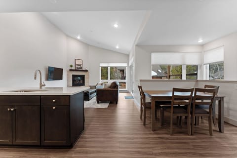 Relax in your spacious open-concept living area with modern kitchen, cozy dining space, and comfortable seating by the fireplace.