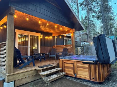 Outdoor living area with oversized hot tub, party lights and BBQ