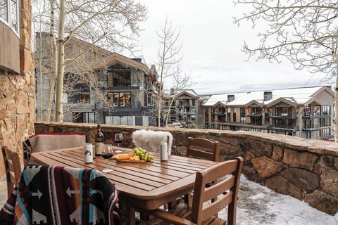 Savor morning coffee on your private terrace, where wooden furnishings and cozy throws create the perfect alpine retreat overlooking charming mountain architecture.