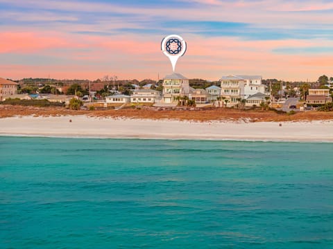 Property location with pristine turquoise waters and sandy shore during golden hour.