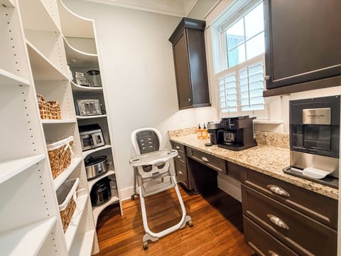 Massive pantry stocked with plenty of appliances, a nugget ice maker, coffee station, and a highchair—designed to make family stays easy and comfortable.