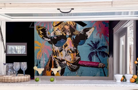 Grab a drink at the Coast & Palms bar—where the flip-up window is open and the legendary cigar-smoking giraffe keeps watch.