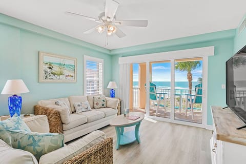Sink into coastal comfort in this bright living room where ocean breezes flow through your private balcony doors.