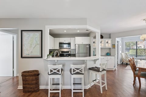 Your open-plan kitchen features white cabinets, stainless steel appliances, and a breakfast bar where you can enjoy morning coffee while admiring the city views.