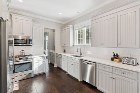 Your fully-equipped gourmet kitchen awaits with pristine white cabinetry, granite counters, and premium stainless steel appliances for memorable culinary adventures.