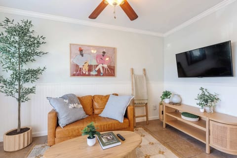 Bright living room with comfortable seating, smart TV, and coastal-inspired décor.