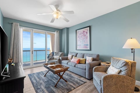 The living room offers a bright and welcoming space with sliding glass doors that open directly onto the balcony, filling the room with natural light and Gulf breezes.