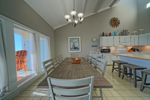 Gather around this refined dining table, perfectly positioned for conversation and coastal views. Your memorable meals await.