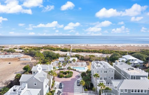 Coastal property community with beach access, featuring swimming pool and modern buildings near pristine shoreline.