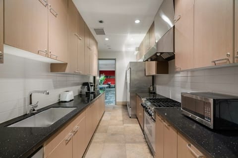 This sleek kitchen features contemporary cabinetry and modern appliances, designed for both functionality and style, perfect for culinary enthusiasts.