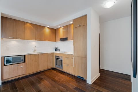 The contemporary kitchen boasts stylish wood cabinetry, state-of-the-art appliances, and an inviting layout perfect for culinary enthusiasts.