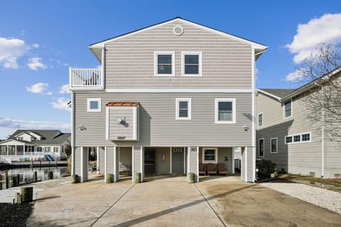 A modern waterfront home with elevated design and covered parking, situated in a peaceful residential neighborhood.