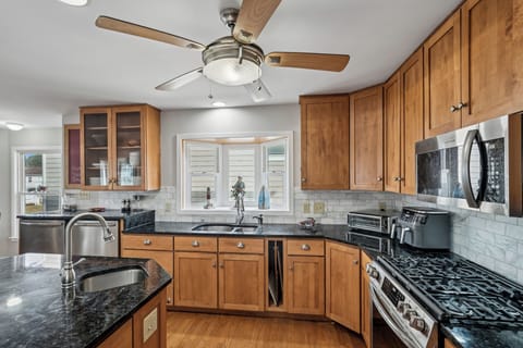 Cook your favorite meals in this fully-equipped kitchen featuring granite countertops, stainless steel appliances, and warm wood cabinetry.