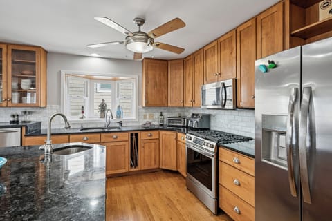 Your fully equipped kitchen features granite countertops, stainless steel appliances, and warm wood cabinetry - perfect for preparing memorable meals together.