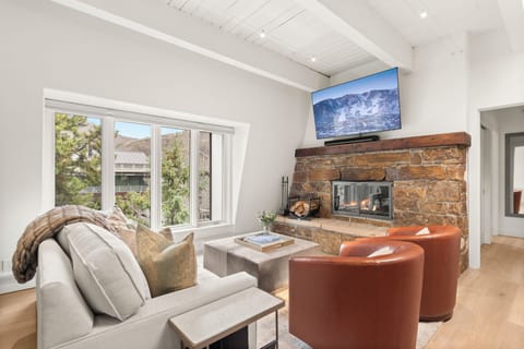 Top-floor sanctuary at Chateau Dumont. This living room features a 65" smart TV with Xfinity cable and Roku Streaming, queen-sized pull out couch, wood-burning fireplace, views of Smuggler and Red Mountain.
