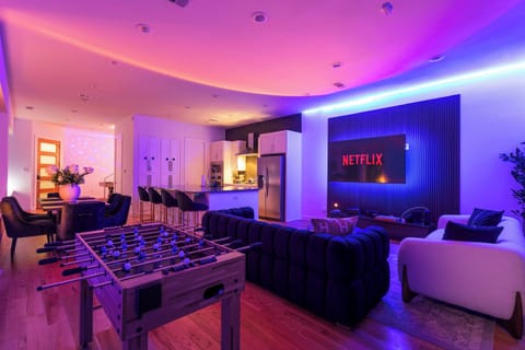 Modern living area with oversized sectional seating, Smart TV, and customizable LED lighting. Ideal for movie nights, social gatherings, or creating your own vibrant evening vibe.