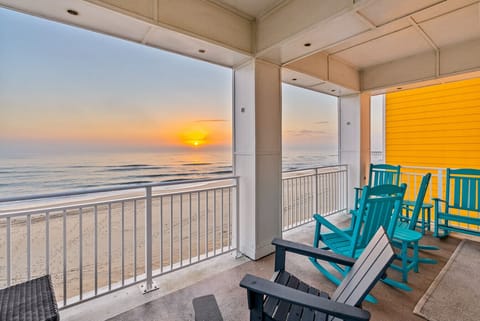 Expansive wraparound balcony with multiple Adirondack chairs—perfect for relaxing, entertaining, and enjoying panoramic ocean views all day long.