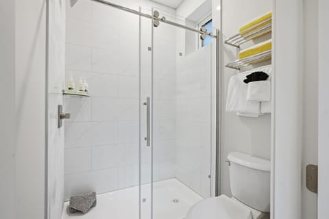 Brand new bathroom featuring a stand-up shower and toilet