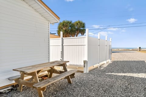 Your private outdoor picnic table offers perfect spot for meals with coastal breezes and palm tree shade nearby.