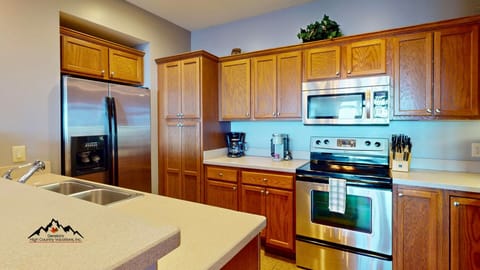 Your fully equipped kitchen features rich wood cabinets, stainless steel appliances, and ample counter space for creating memorable meals during your stay.