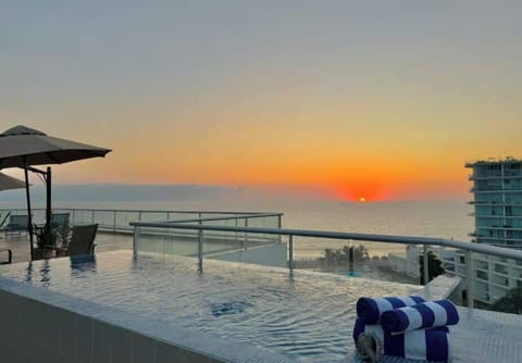 Spacious terrace w/ seating & glass railing, perfect for sunset views over the water