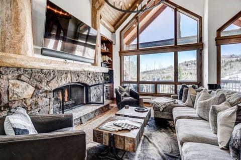 Relax in our bright living room, featuring panoramic windows, cozy seating, and a flat-screen TV. Enjoy stunning views of the surrounding landscape.