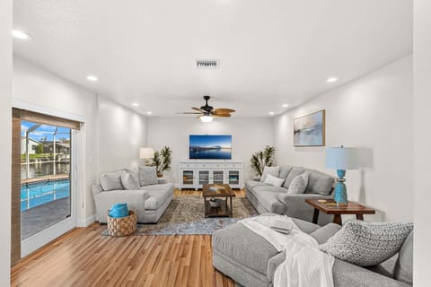 Bright & airy living room with sliding glass doors that lead to an outdoor patio with a pool
