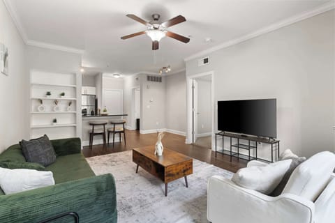 Spacious, sun-filled living room with smart TV and cozy seating — perfect for work, rest, and entertainment.
