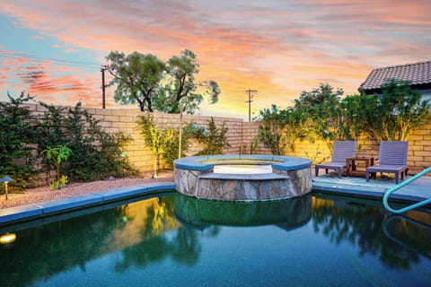 Backyard spa at sunset with glowing landscape lights