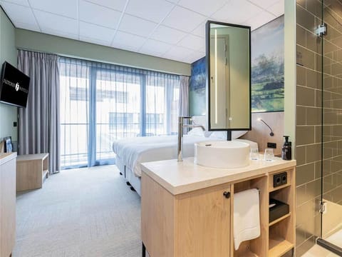 Drift off in crisp linens beside sunlit floor-to-ceiling windows.