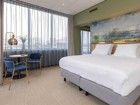 Sink into plush bedding beside a cozy corner coffee table.