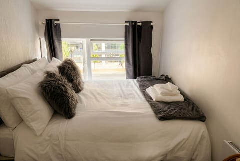 Bright double bedroom with fresh white linens and towels ready for your arrival.