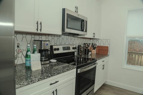 A thoughtfully curated kitchen designed for elevated living, featuring stainless steel appliances, granite countertops, and a full collection of cookware and essentials. Whether preparing a leisurely breakfast or a refined dinner, everything you need